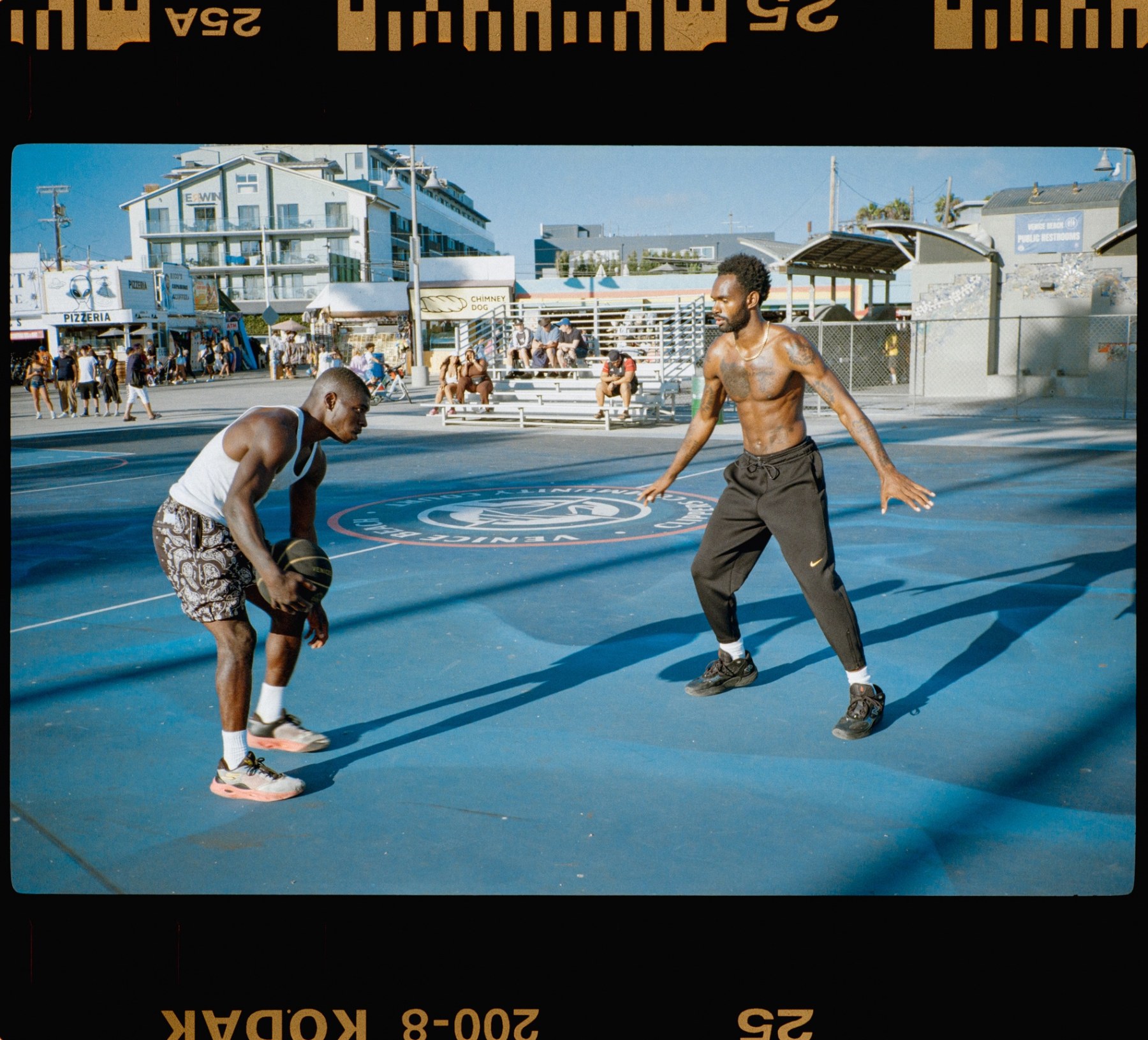 Two players face off on the blue Venice Beach basketball court